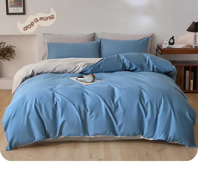 A light blue quilted duvet cover set with matching pillowcases on a bed.