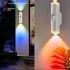 A white smart night light illuminates a colorful gradient effect on a wall, showcasing various light patterns.