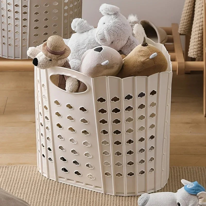 A white folding laundry basket filled with soft stuffed toys and a straw hat