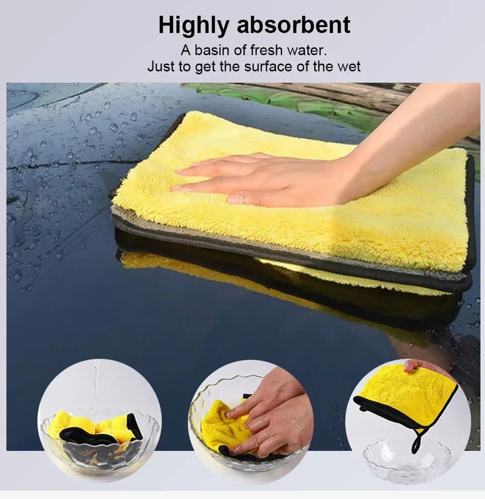 Yellow microfiber car cleaning towels soaking up water on a dark surface.