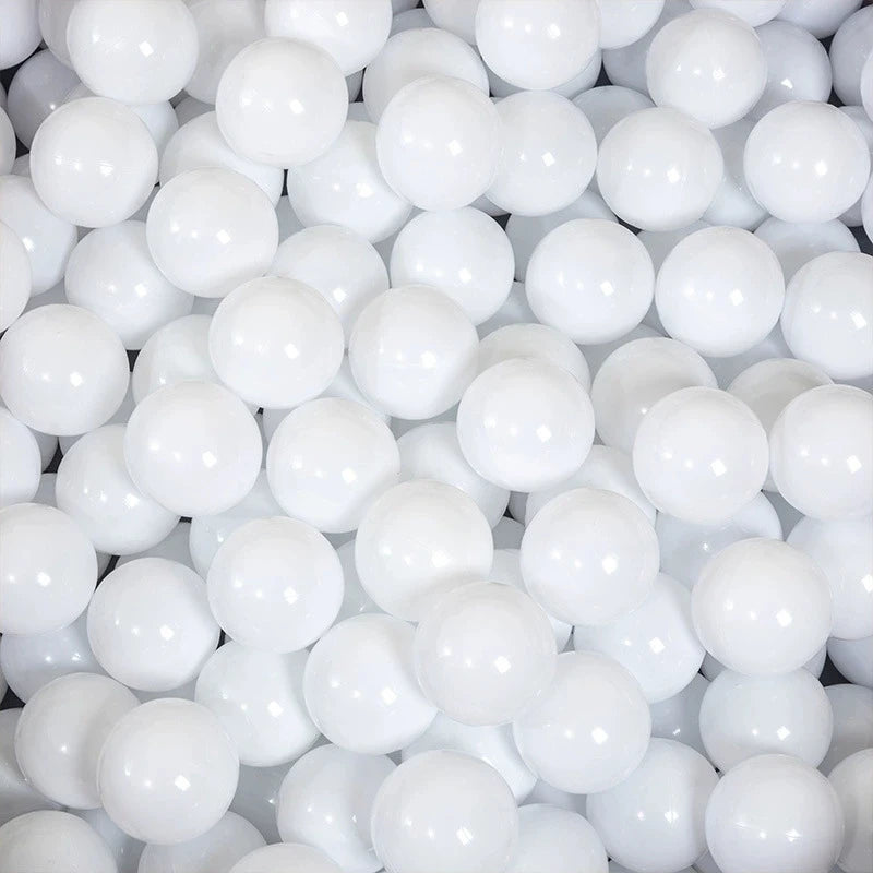 A close-up view of a large quantity of white, spherical ball pit balls.