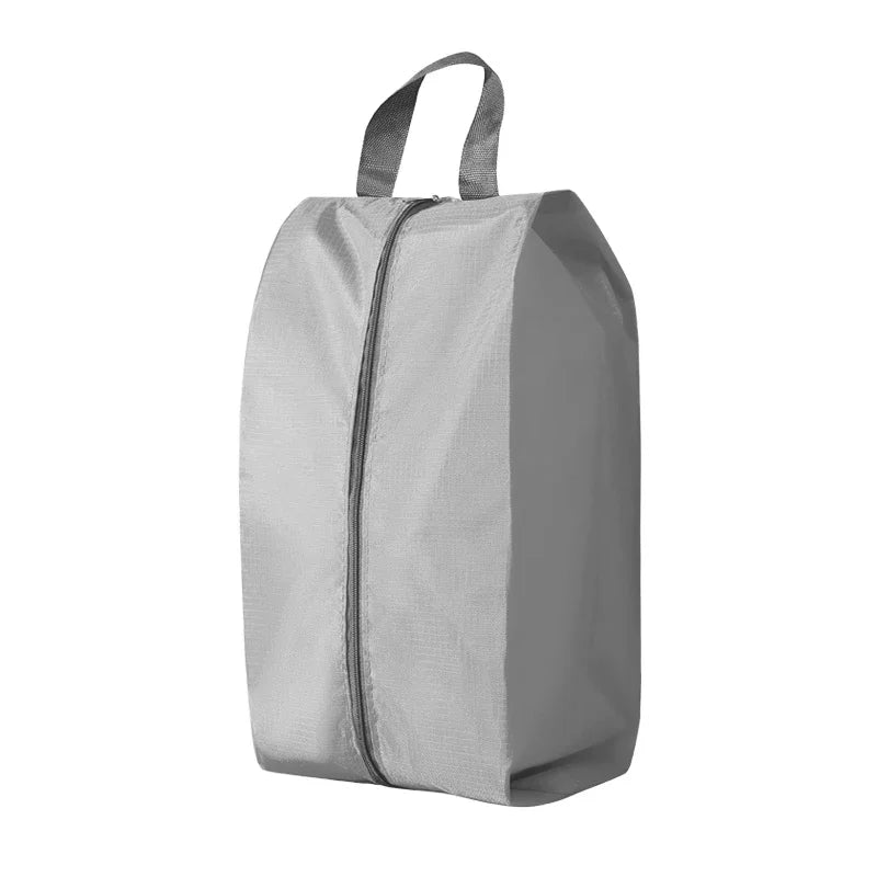 A gray foldable nylon shoe storage bag with a zippered top.