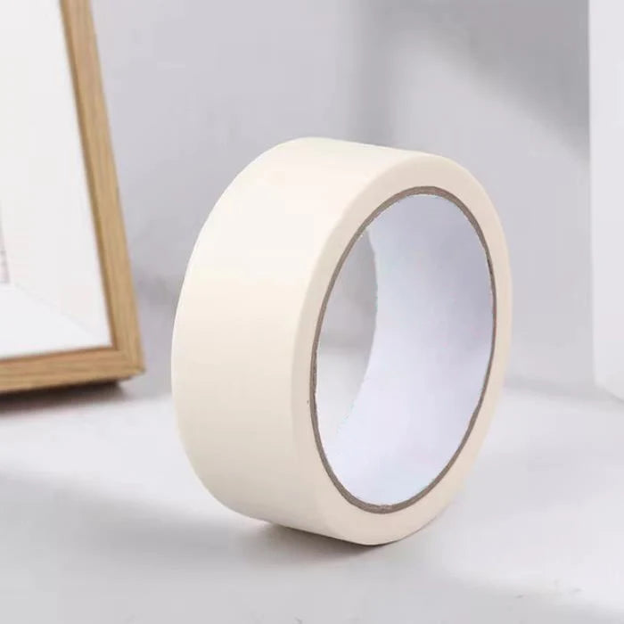A roll of white masking tape with a clear plastic window, shown next to a wooden frame.