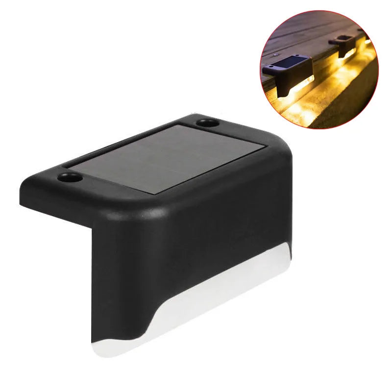 A black solar deck light with a translucent panel, shown next to an inset image demonstrating its outdoor illumination.