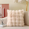 A fluffy beige decorative pillow cover resting on a light-colored sofa.