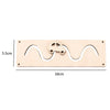 A light wood Montessori busy board featuring a wavy cutout design and a small wooden puzzle piece.