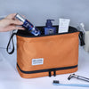 An orange toiletry bag for men with a blue bottle of Nivea Men and other grooming products.
