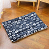 A dark blue plush mat patterned with white cats and dogs is placed on a wooden floor.