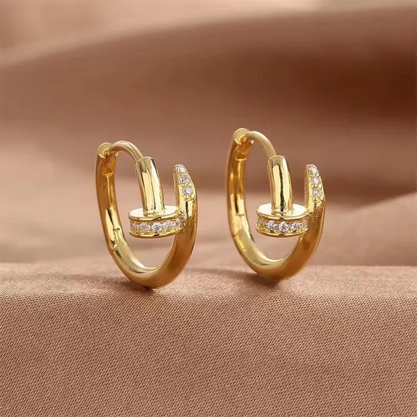 Par de aretes de aro dorados con pequeñas cristales transparentes.