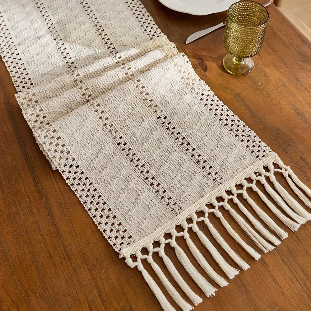 Beige bohemian farmhouse table runner with fringe detail on a wooden surface.