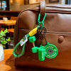 A green fitness keychain hangs from a brown leather backpack.