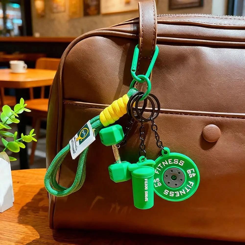 A green fitness keychain hangs from a brown leather backpack.