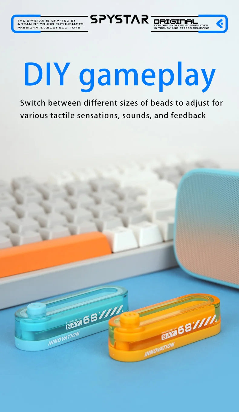 Two plastic fidget sliders, one blue and one orange, are shown on a blue surface next to a white keyboard.