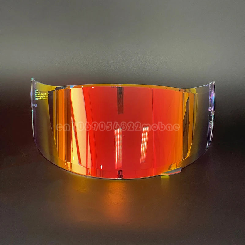 A replacement motorcycle helmet visor with a vibrant orange-red tint displayed on a dark surface.