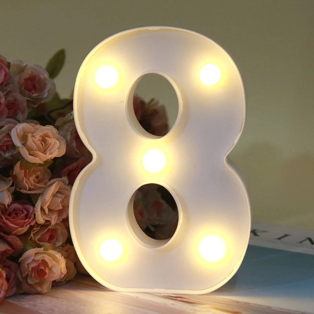Lumière d'alphabet LED blanche en forme de huit posée sur une surface en bois.
