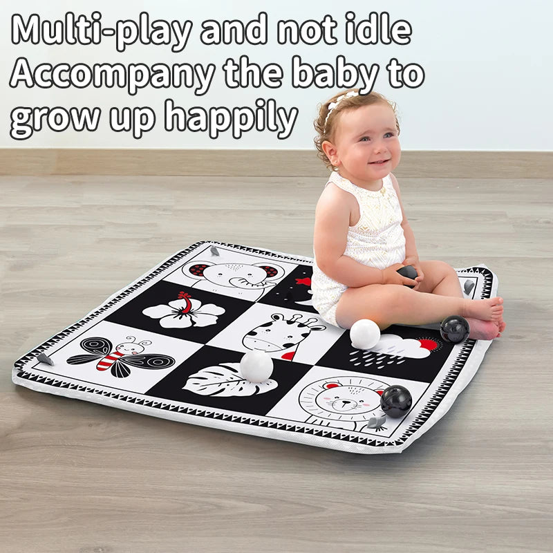 A happy baby sitting on a multi-play activity mat featuring various animal shapes and toys.
