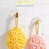 A yellow cheese bath ball and a pink cheese bath ball are hanging on a white tiled wall.