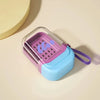 A leakproof travel soap case with a purple and light blue lid and silicone grip is shown on a beige surface.