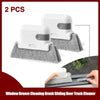 Two white window groove cleaning brushes with gray heads shown next to a wooden door track.
