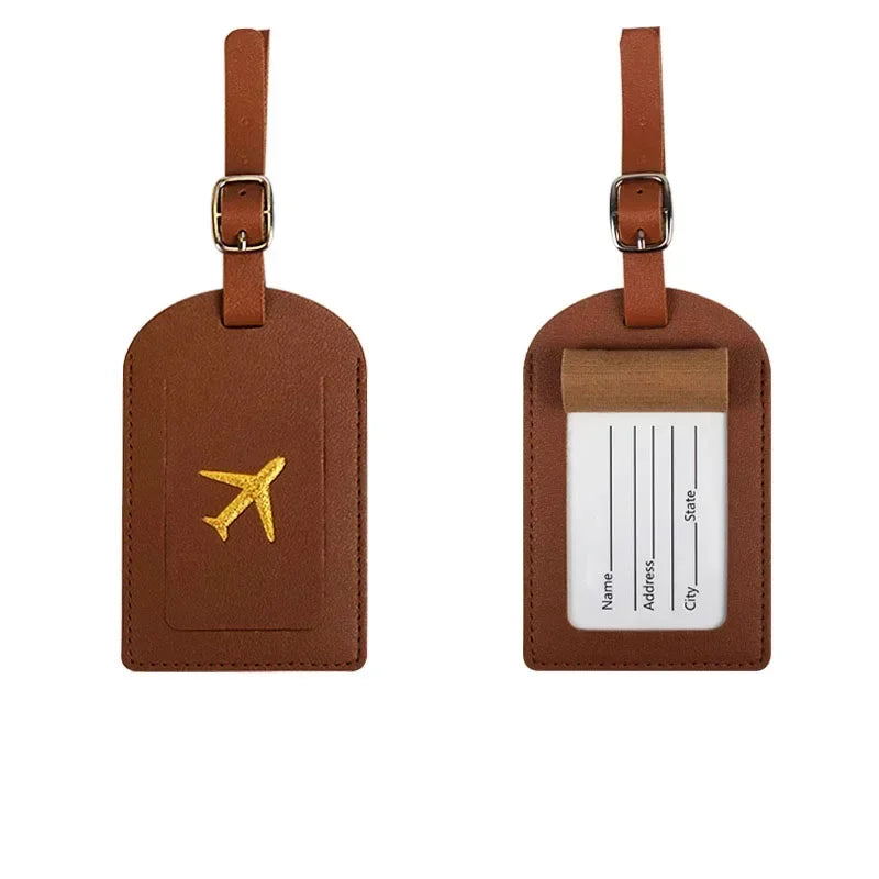 A brown PU leather luggage tag with a gold airplane emblem and a clear plastic section for personal information.