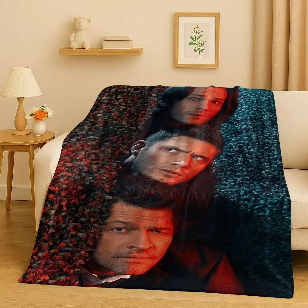 A dark green flannel throw blanket featuring a collage of faces from the Supernatural TV show.
