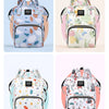 A light blue and green patterned waterproof backpack for a diaper bag featuring stroller straps.