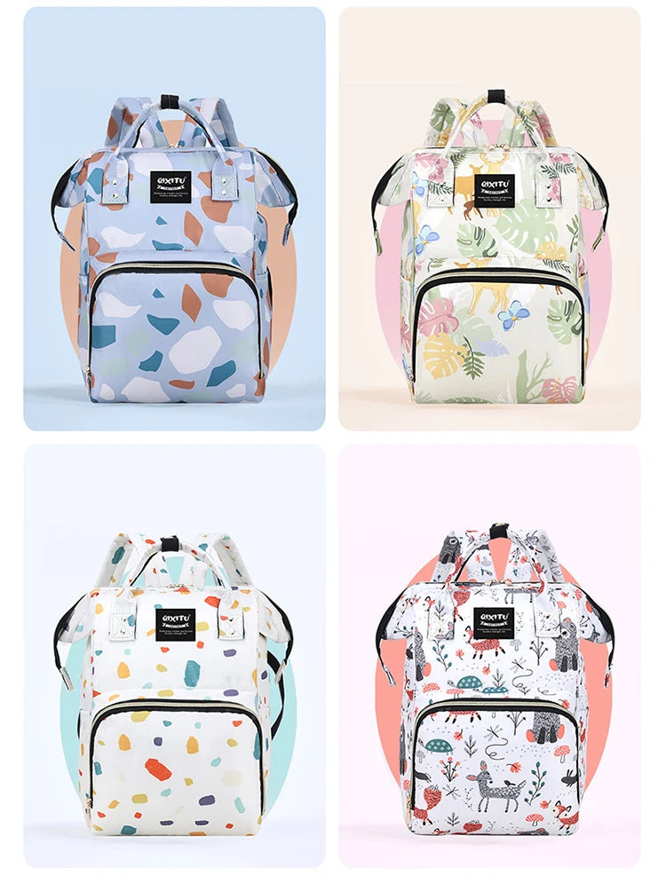 A light blue and green patterned waterproof backpack for a diaper bag featuring stroller straps.