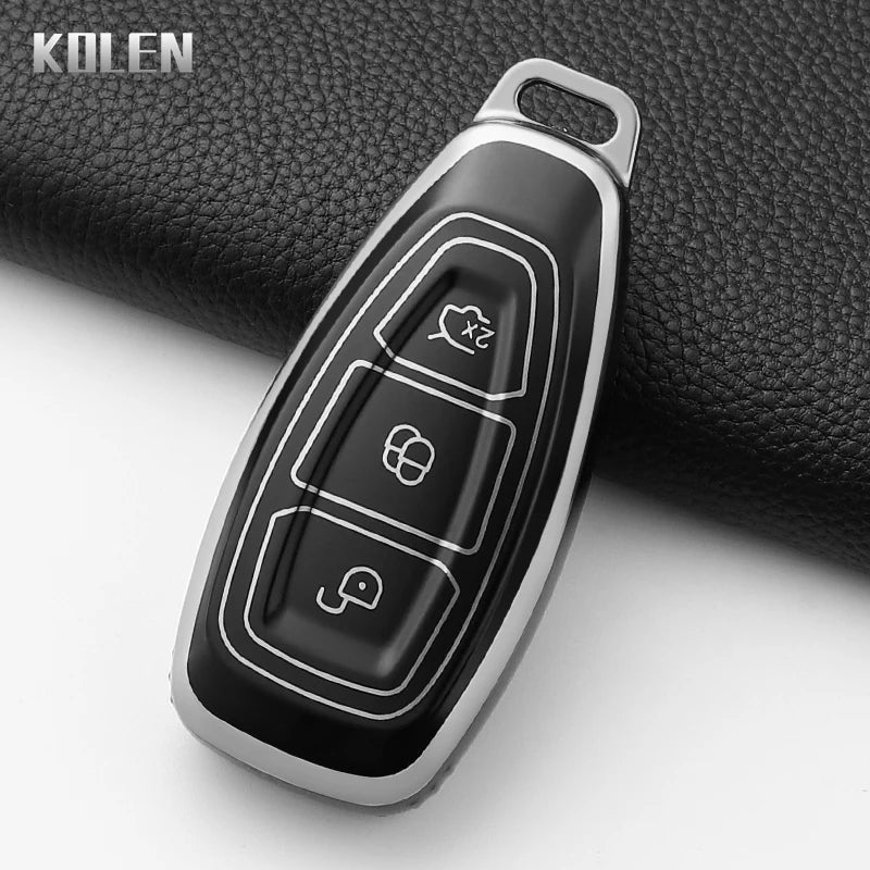 A black silicone car key fob cover with silver accents is shown against a dark background.