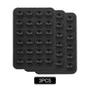 A set of three black reusable silicone suction phone mounts arranged in a rectangular tray.