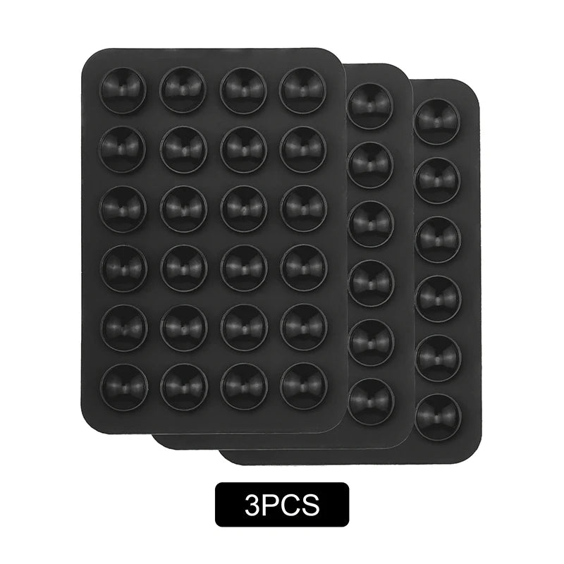 A set of three black reusable silicone suction phone mounts arranged in a rectangular tray.