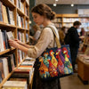 A woman holds a colorful vintage quilted tote bag while browsing books in a bookstore.