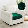 A white upholstered armchair with a dark green seat cover and a decorative green fabric accent.