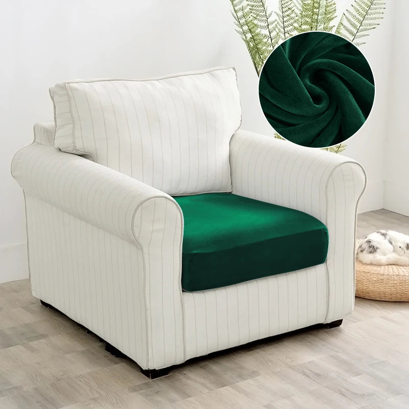 A white upholstered armchair with a dark green seat cover and a decorative green fabric accent.