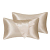 A set of two silky satin pillowcases in a champagne beige color.