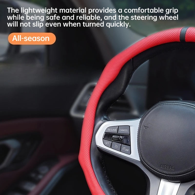 Close-up of a red and black perforated leather steering wheel cover with an airbag visible.