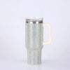 A silver rhinestone bling tumbler with a straw and handle is shown against a white background.