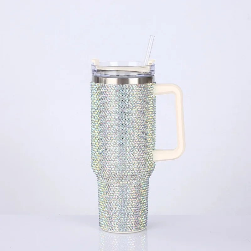 A silver rhinestone bling tumbler with a straw and handle is shown against a white background.