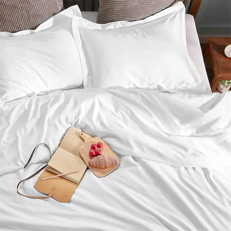 Weißes Luxus-Bambusbettwäscheset mit Kissen und einem Holzservierbrett mit Obst
