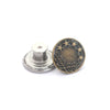 A round, antique brass button with five stars and a wreath design, shown next to its silver mounting base.
