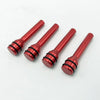 Four shiny red aluminum alloy car door lock pins shown diagonally on a white background.