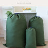 A large, olive green canvas storage bag with a drawstring closure is displayed on a shelf.