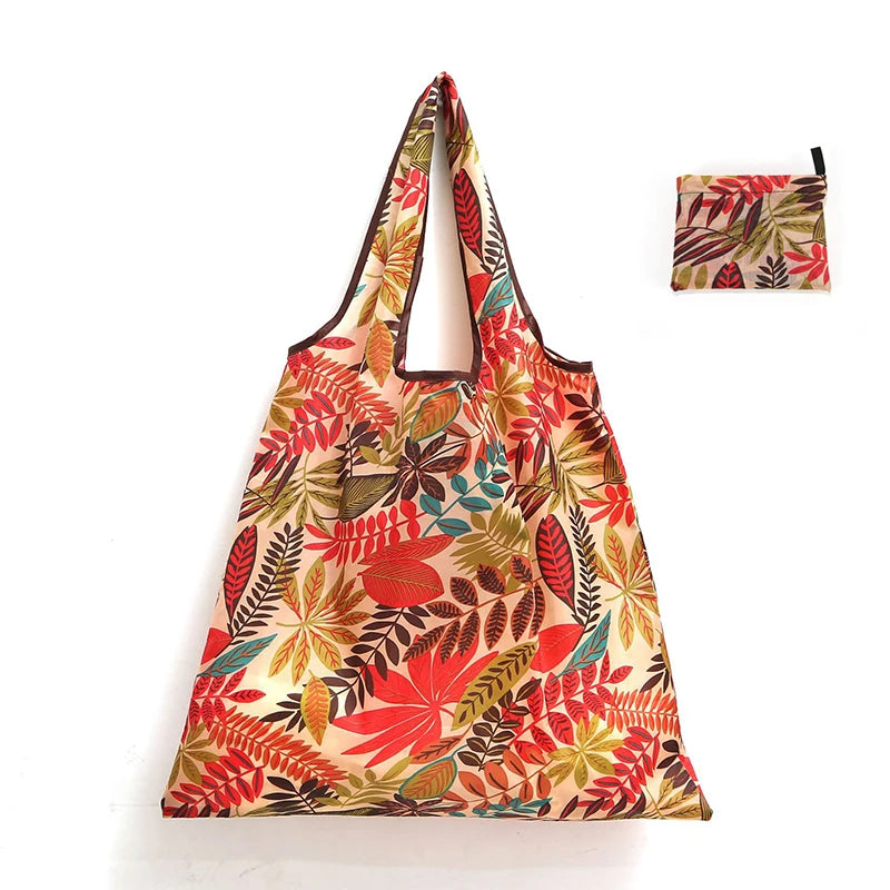 A reusable shopping tote bag featuring a floral pattern in shades of red, green, and beige.