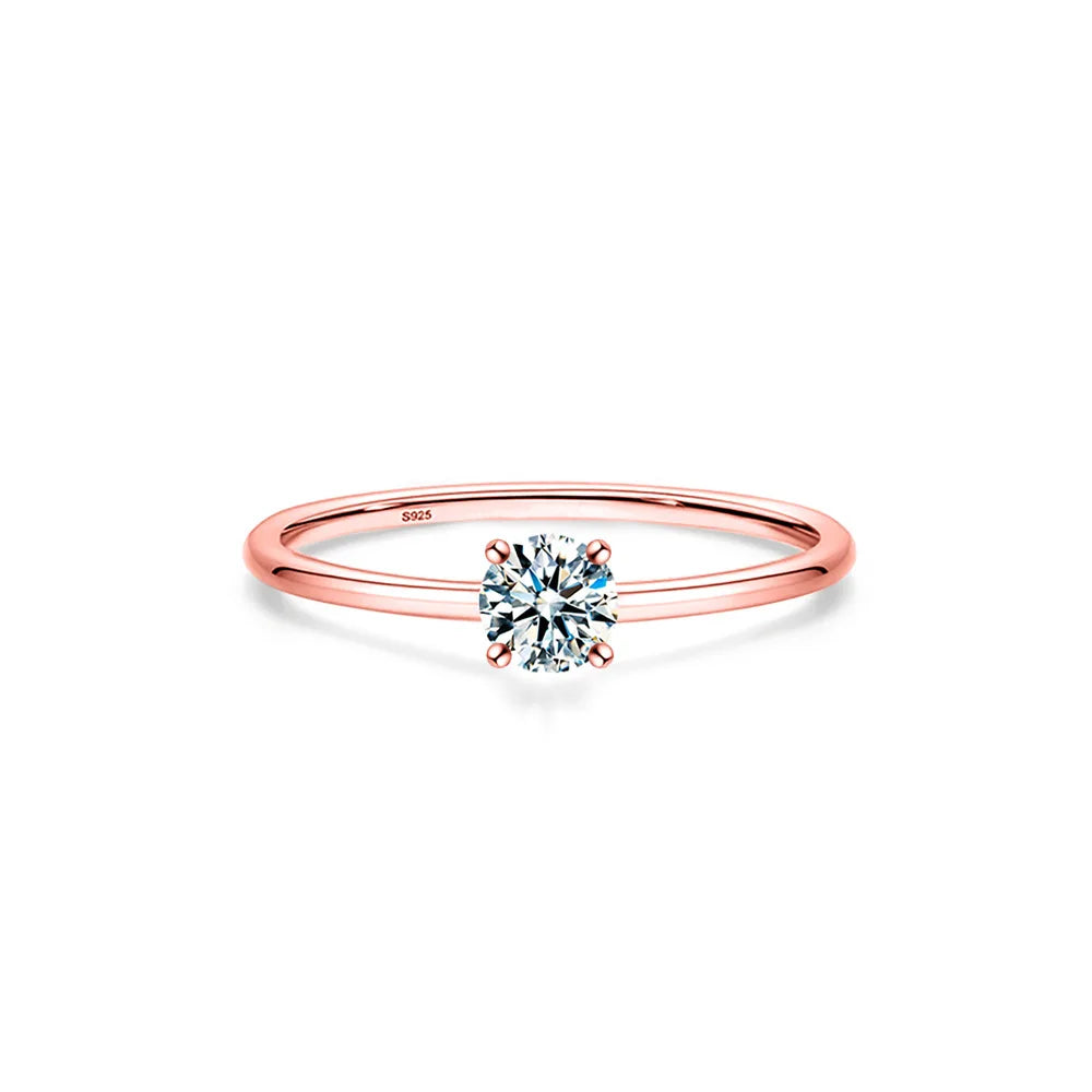 A minimalist moissanite solitaire ring in rose gold band with a brilliant clear stone.