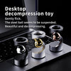 A metal magnetic levitating spinning top toy resting on a laptop keyboard.