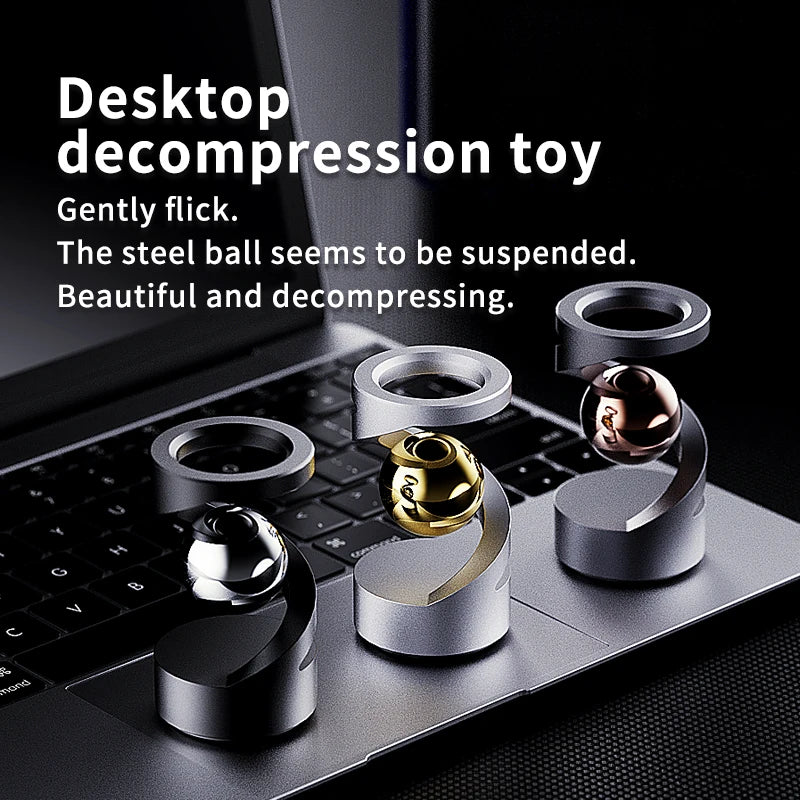 A metal magnetic levitating spinning top toy resting on a laptop keyboard.