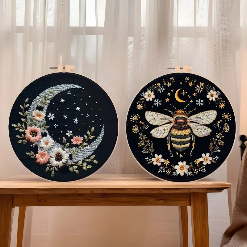 Black embroidery art featuring a golden butterfly and silver crescent moon on a circular canvas