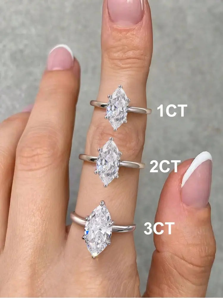Trois bagues en argent sterling empilées avec des pierres de zircon taillées en marquise, étiquetées 1CT, 2CT et 3CT sur une 