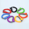 A collection of colorful ergonomic grocery bag carriers with soft-grip handles arranged in a circle.