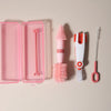 A pink silicone baby bottle cleaning set featuring a bottle brush, a cleaning brush, and a silicone comb.