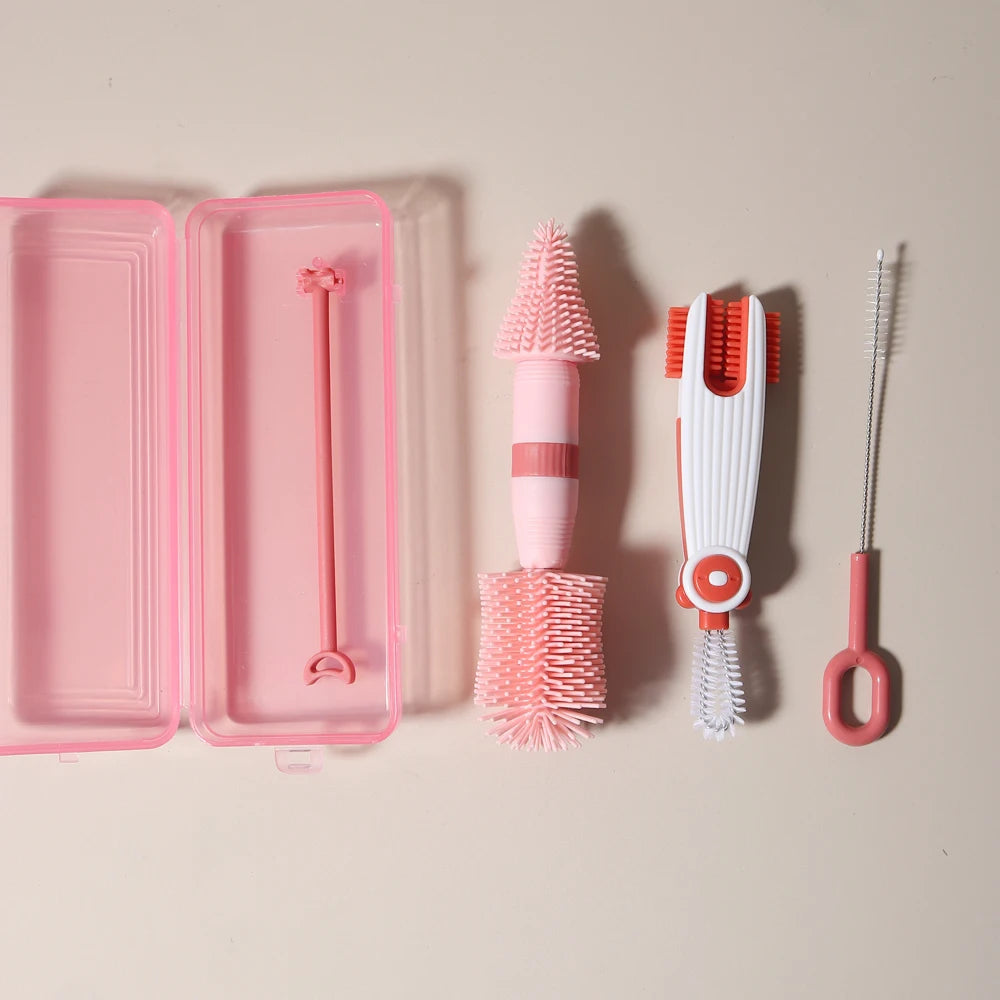 A pink silicone baby bottle cleaning set featuring a bottle brush, a cleaning brush, and a silicone comb.